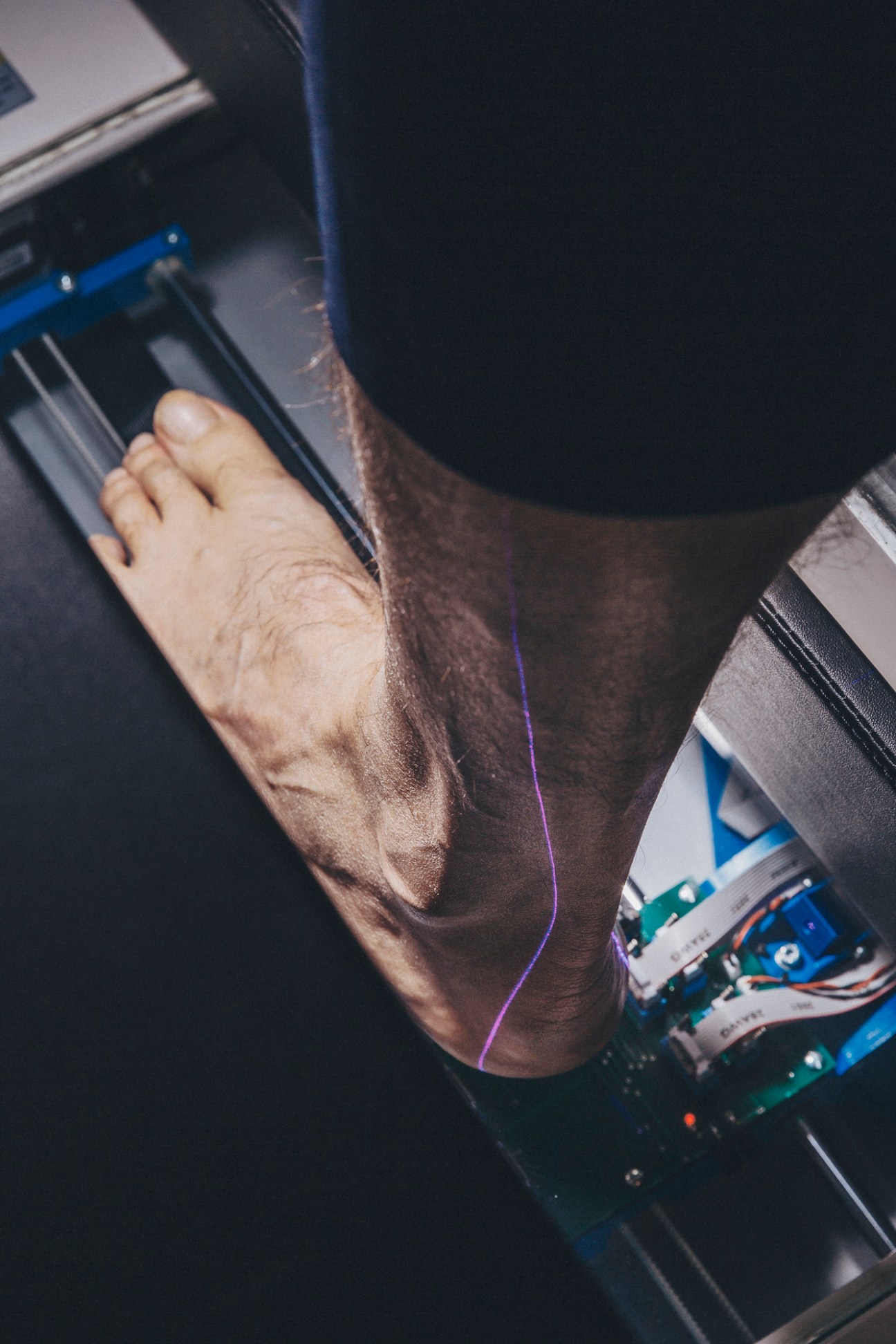 A foot being scanned by a 3D laser scanner device for custom shoe measurements