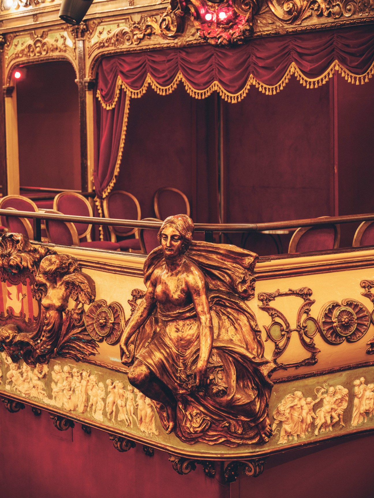 Ornate golden decorative sculpture of a nymph on ornate ballroom balcony