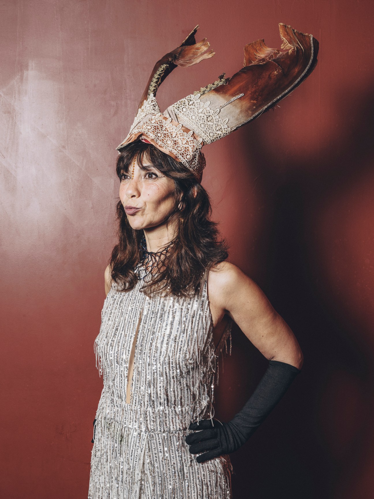 Woman in ornate horned headdress and beaded fringe dress posing at carnival celebration