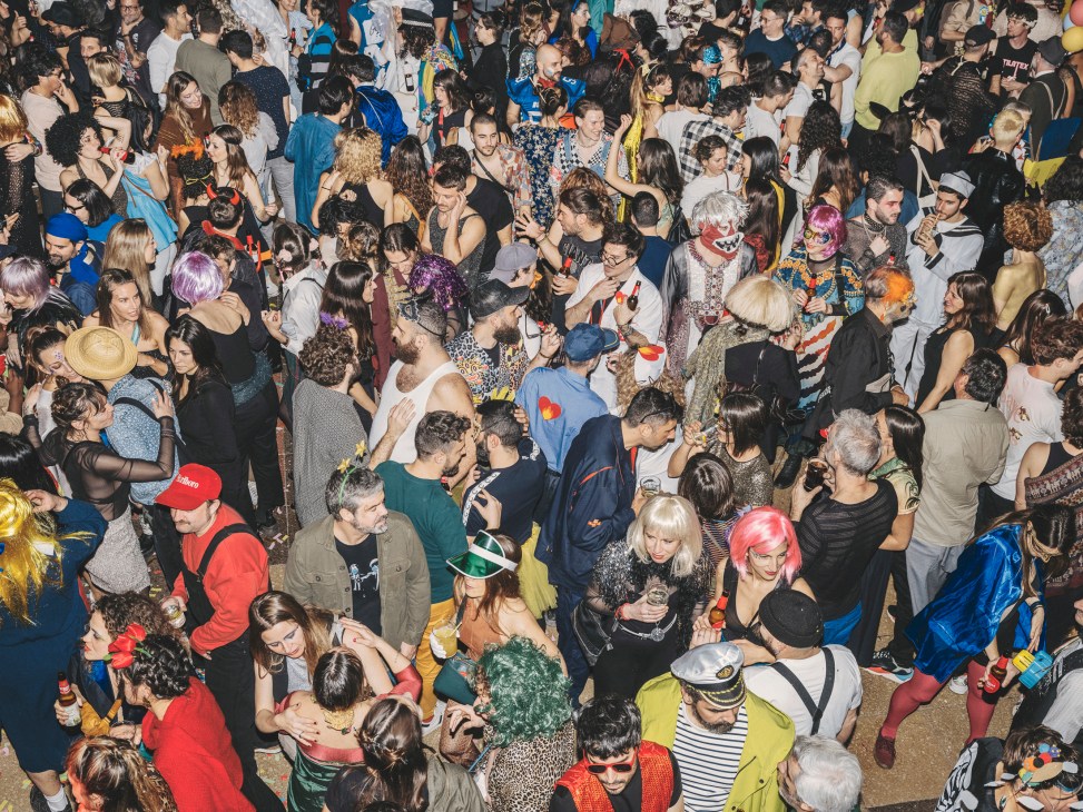 Crowd of costumed revellers dancing at La Paloma's Glove Carnival Party in ornate ballroom