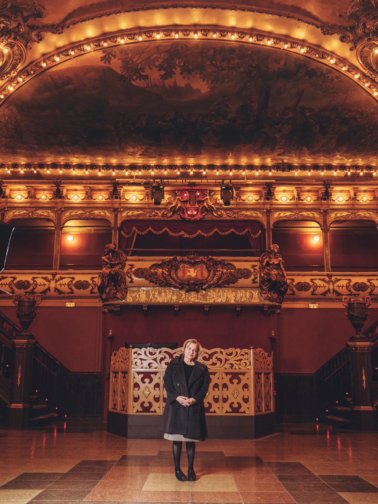 Mercè March stands in the ornate interior of La Paloma dance hall with its elaborate golden balconies and ceiling