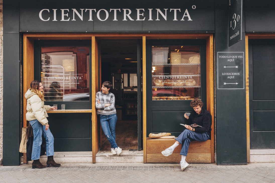 Busy interior of Cientotreinta Grados bakery with customers seated and standing