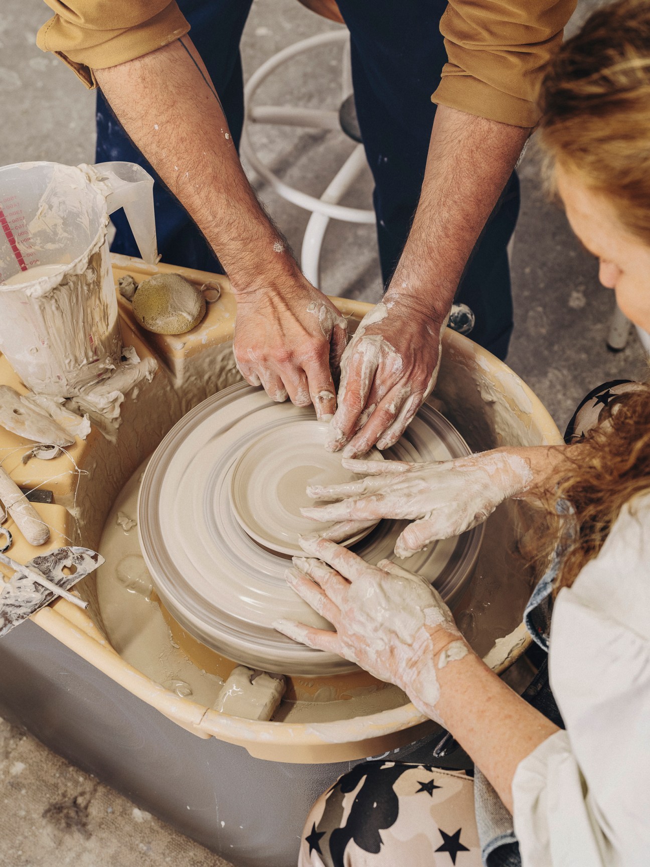 Student working hands-on with clay at pottery wheel
