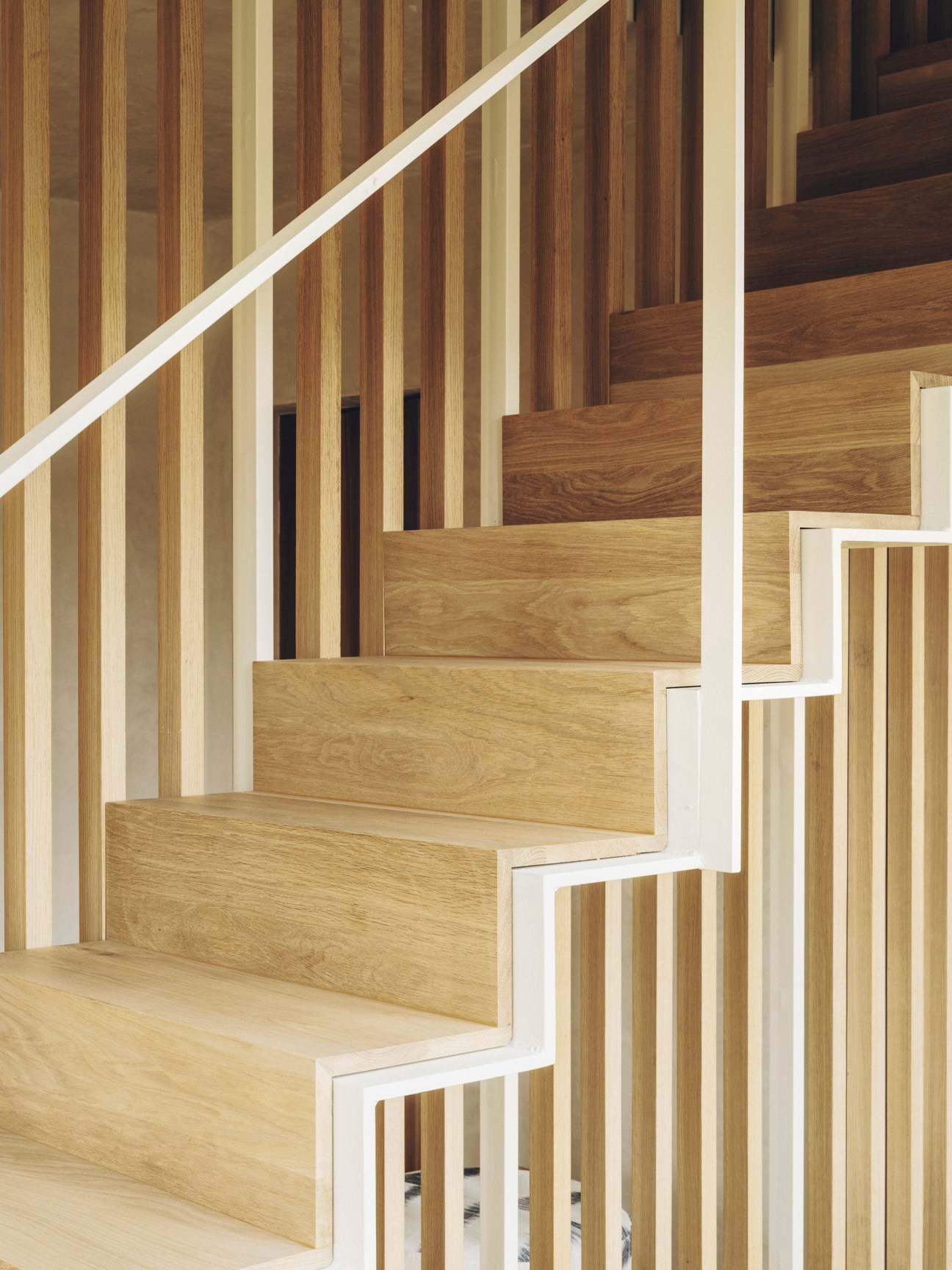 Modern wooden staircase with vertical timber slats and integrated geometric storage compartments