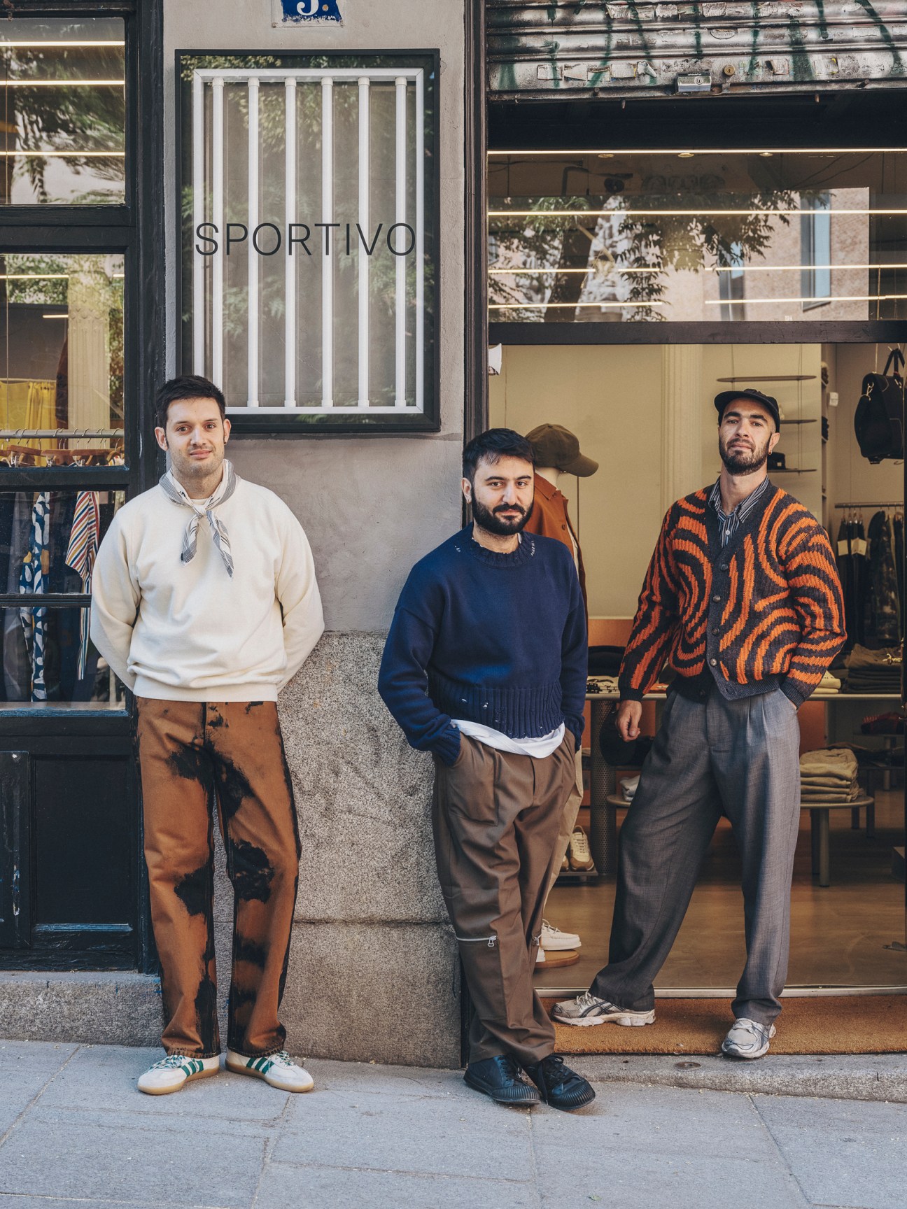 Three men standing outside Sportivo menswear store in Madrid