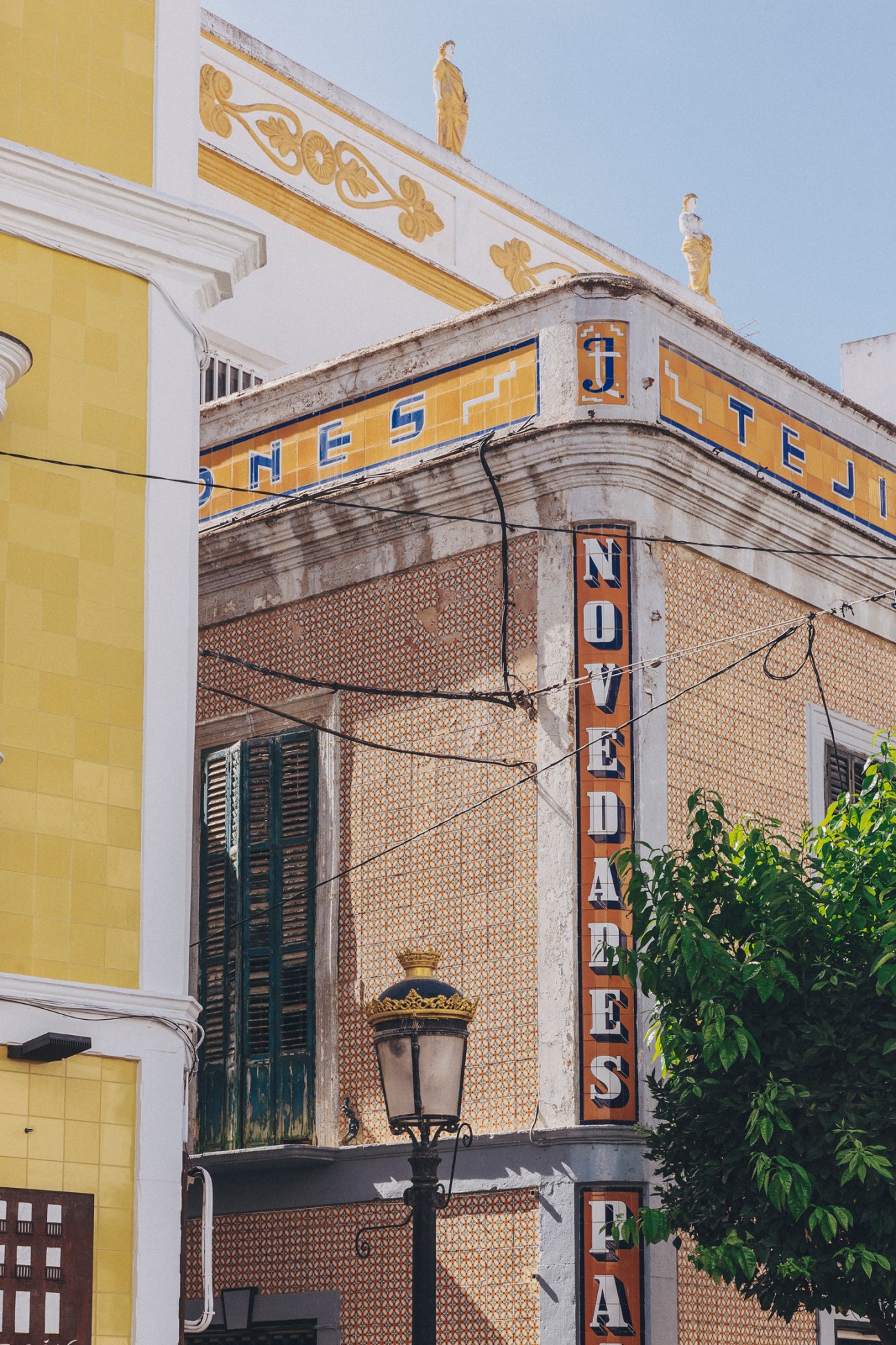 Weathered old town building facade with yellow signage and ornamental details in Tarifa.