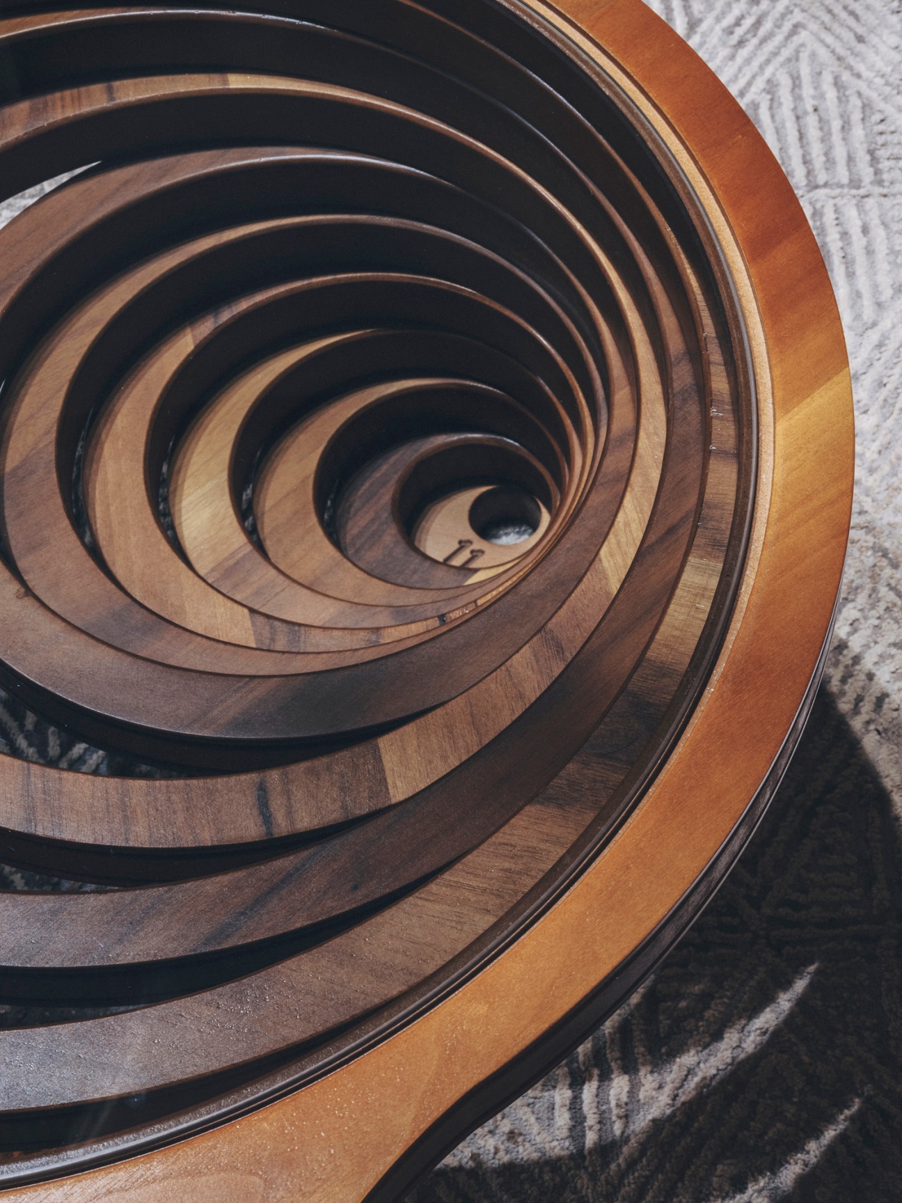 Spiral wooden coffee table with concentric circular rings showing natural wood grain and craftsmanship