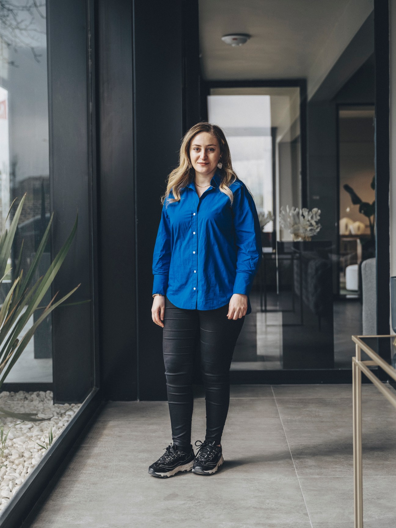 Aliye Betül Gülec, export manager at N Design furniture company, standing in modern office hallway