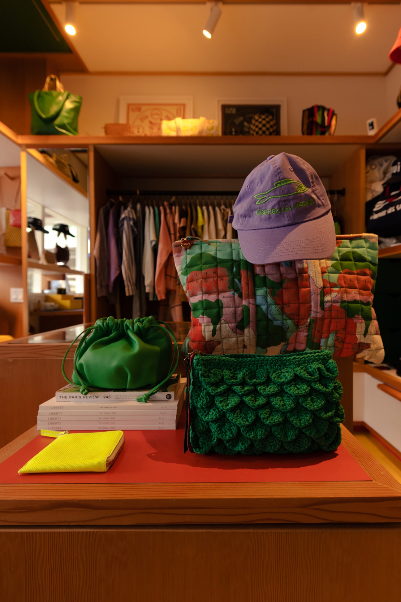 Display of bags, caps and books arranged on a wooden counter in a retail store