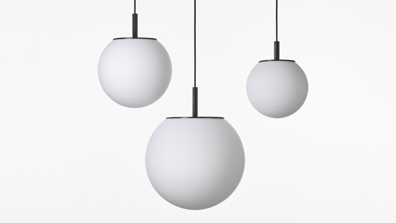 Three white spherical pendant lights with black metal fixtures hanging at different heights