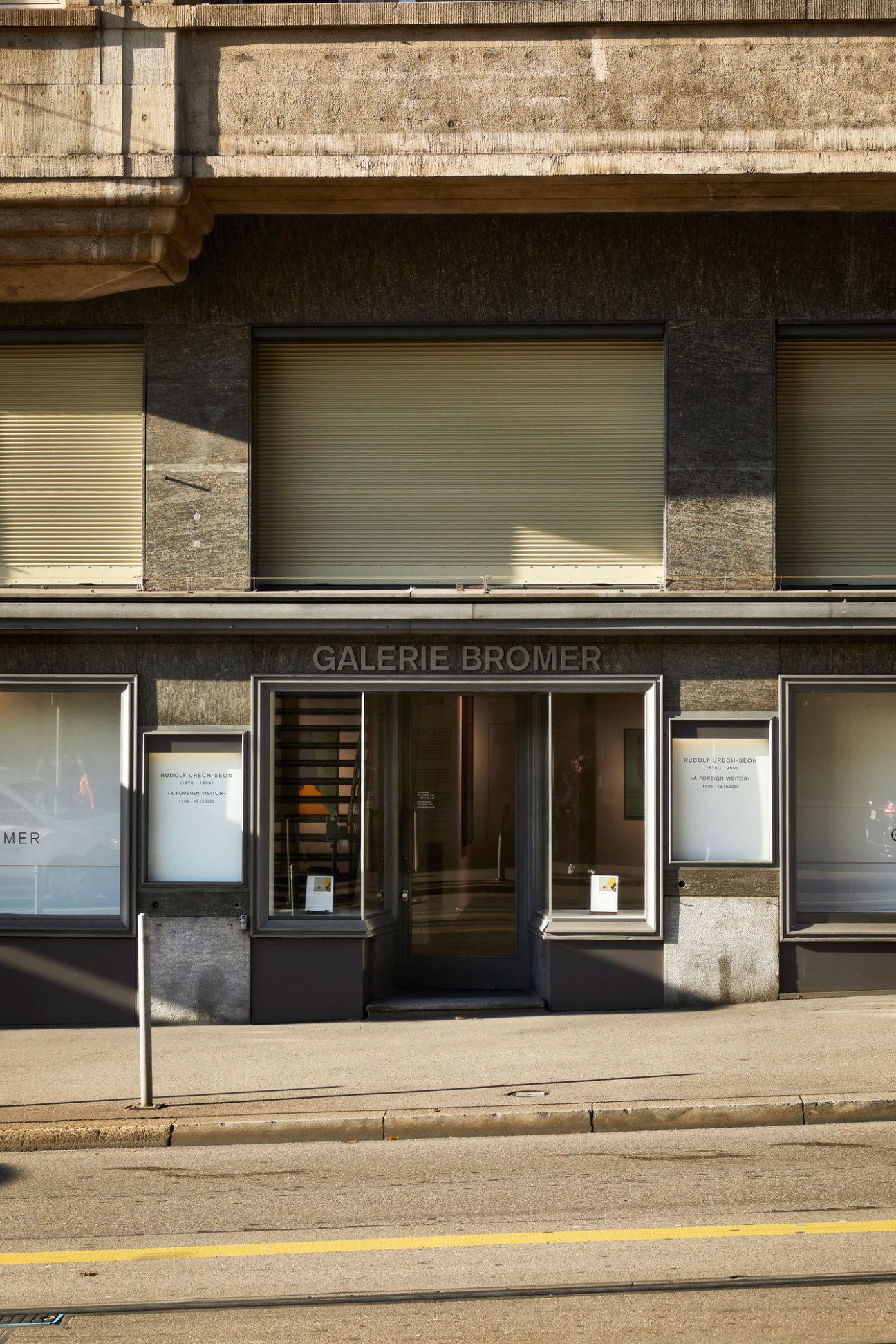 Exterior storefront of Galerie Bromer with glass windows and concrete building facade