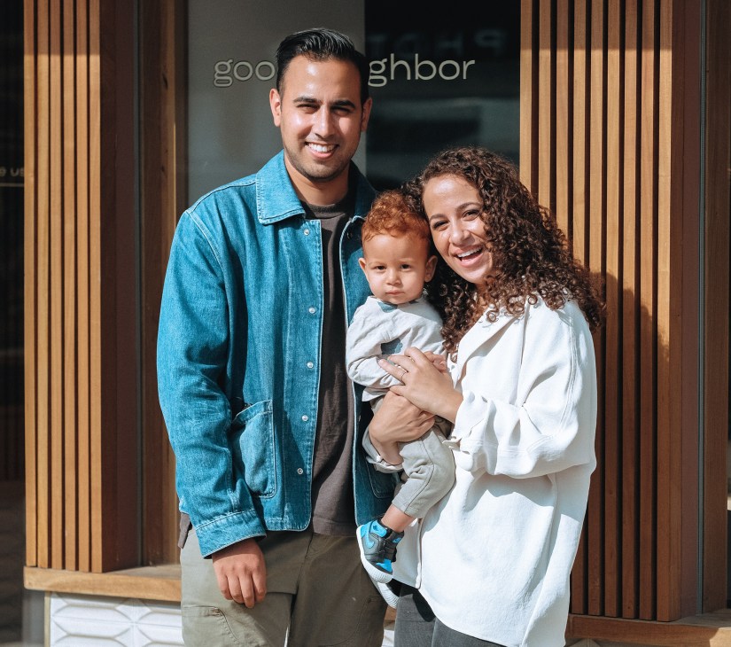 Family of three standing outside Good Neighbor storefront in Baltimore