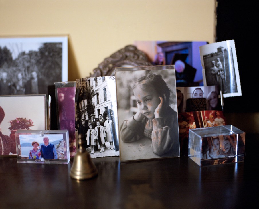 Collection of framed photographs and personal memorabilia displayed on a dark wooden surface