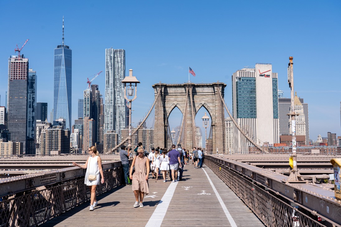 Brooklyn Bridge with pedestrians and cyclists crossing, showing current mixed traffic conditions