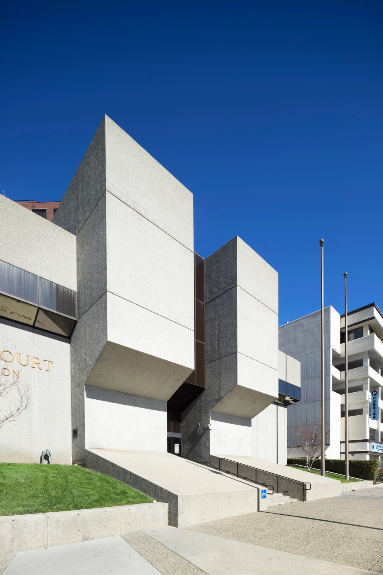 Brutalist concrete bank building with geometric angular facade and white stone elements