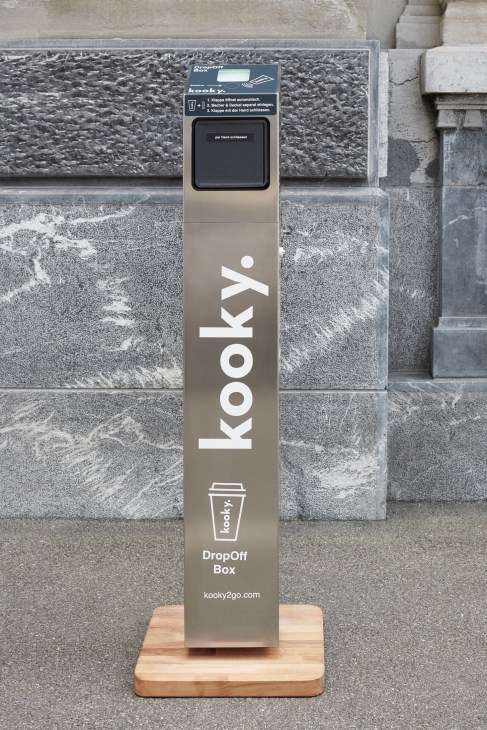 Kooky reusable coffee cup drop-off box with contactless return slot on a street.