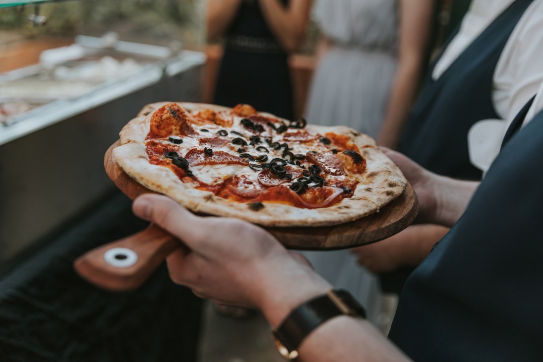 Pizza being prepared in the Happy Camper Pizza mobile kitchen