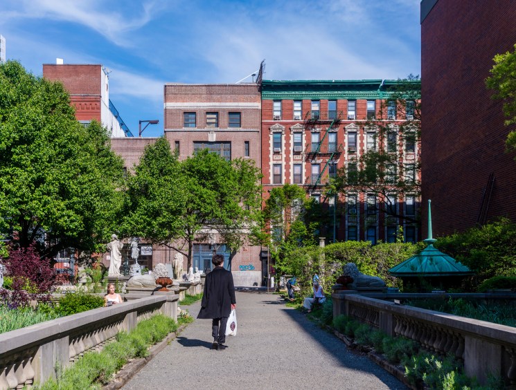 Elizabeth Street Garden with stone sculptures and monuments among greenery in Manhattan