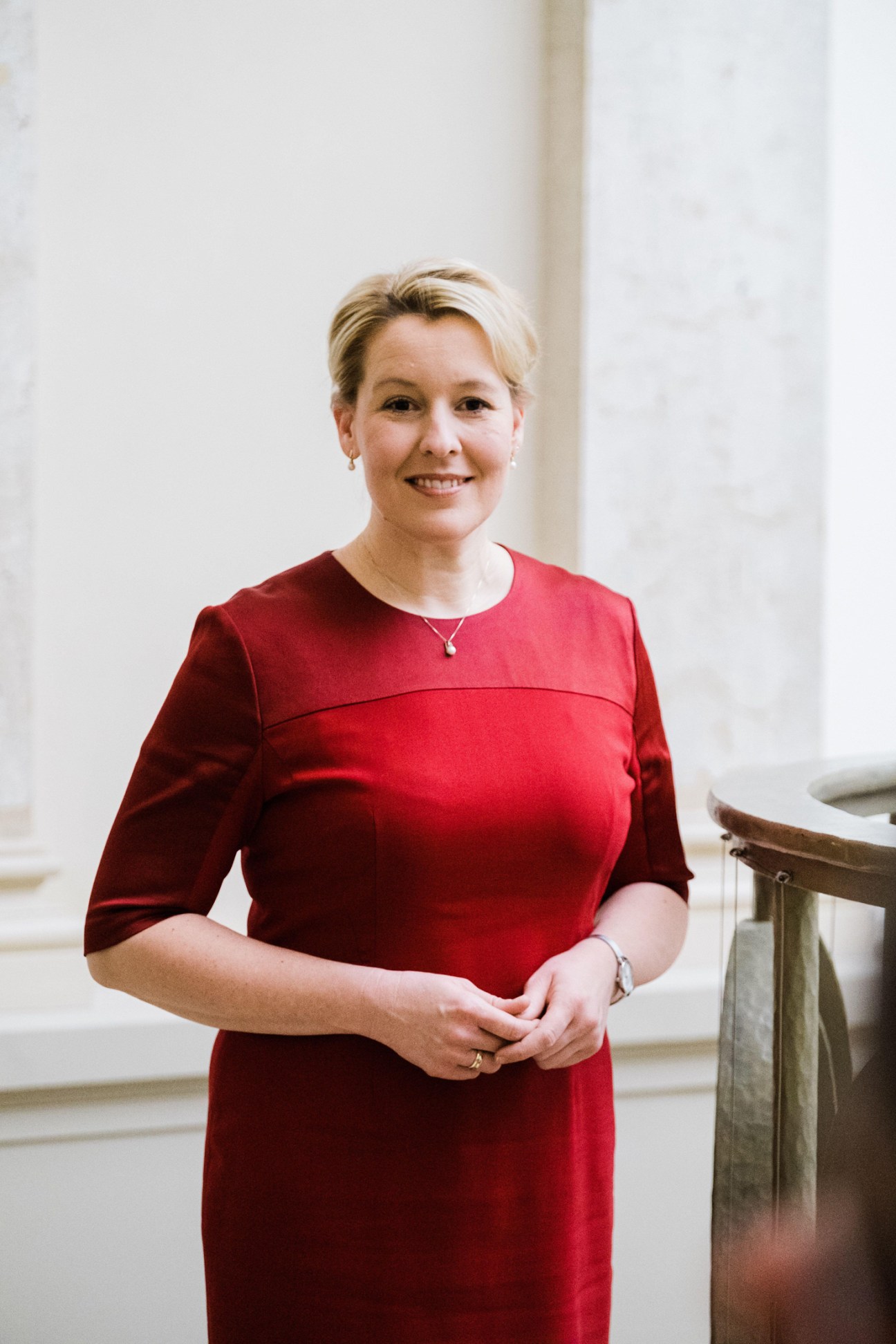 Berlin Mayor Franziska Giffey in a red dress standing in an interior setting