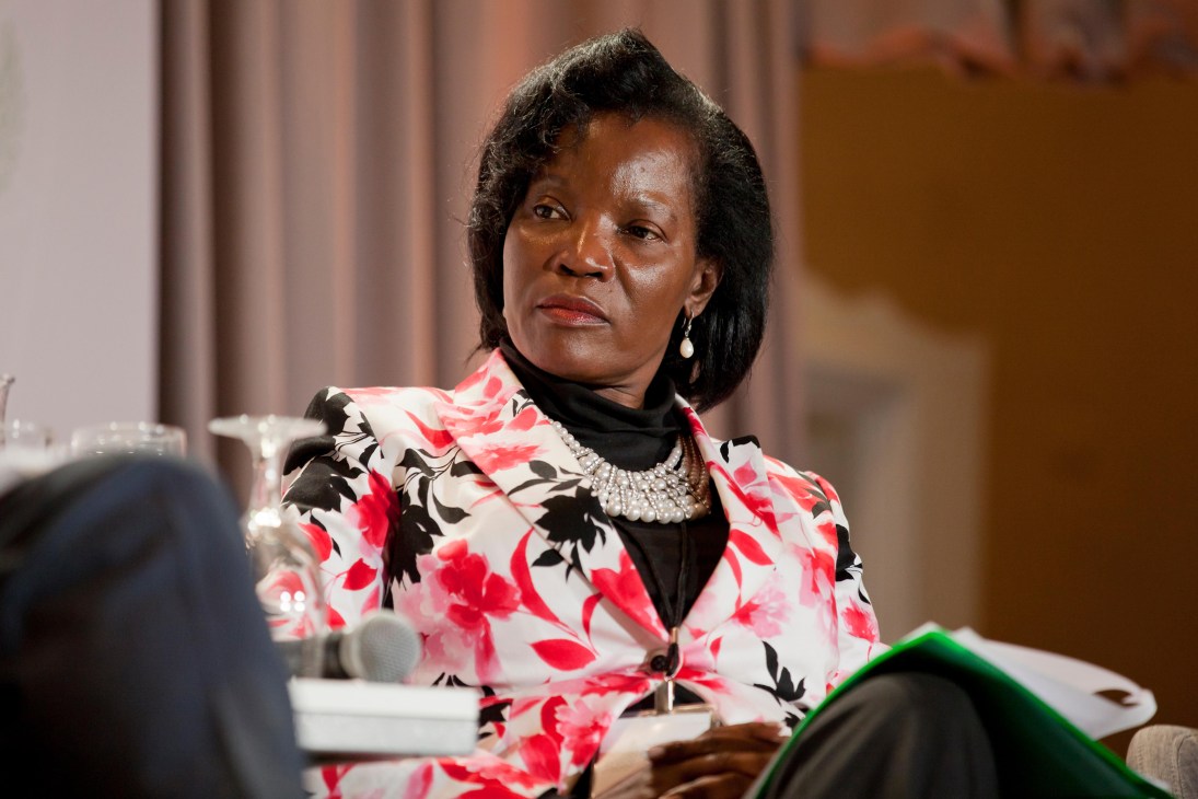 Jennifer Musisi wearing a floral blazer and pearl necklace seated at what appears to be a conference or interview setting