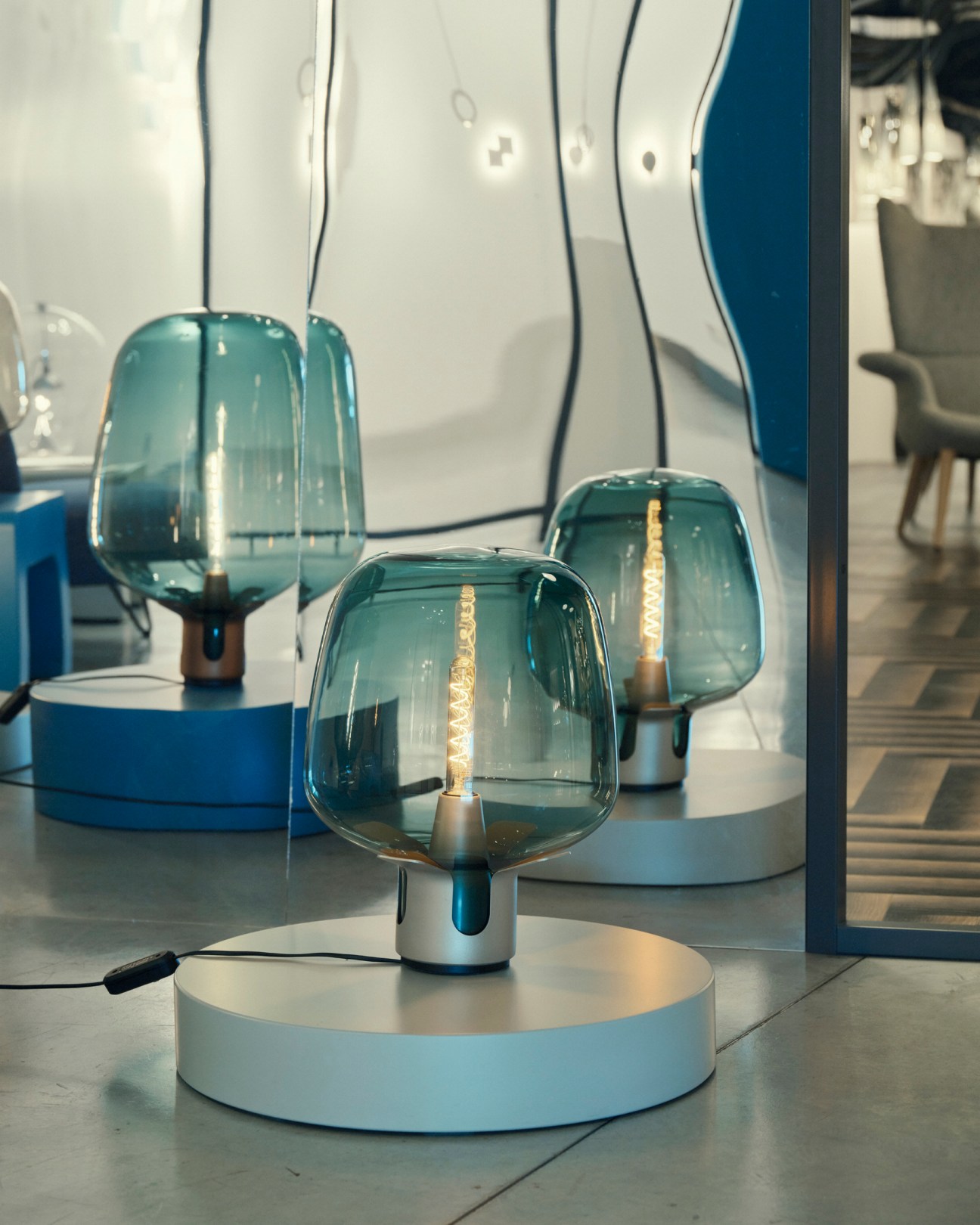 Flar by Patrick Norguet table lamps with teal glass shades and warm LED bulbs on white circular bases