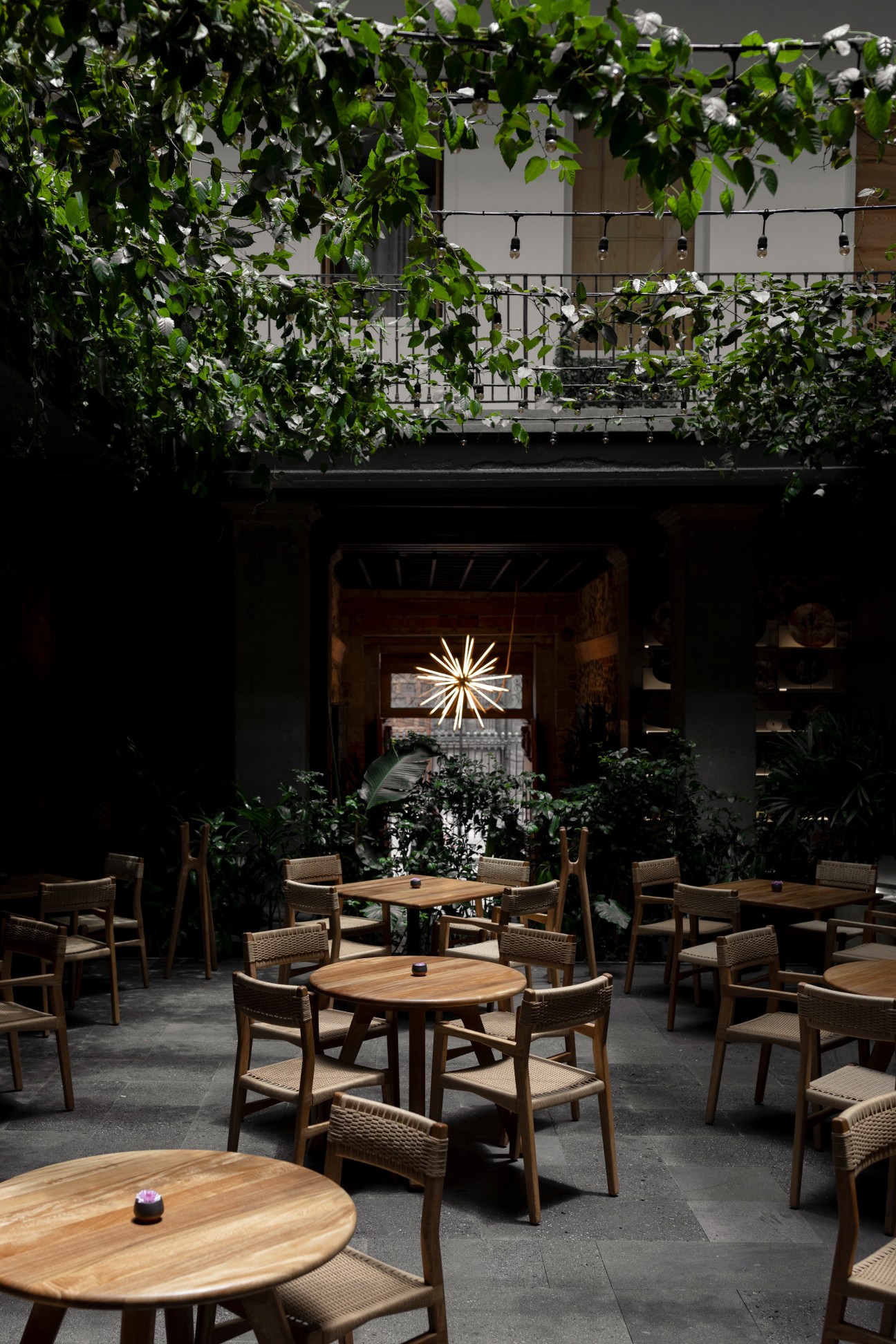 Interior view of Caracol de Mar restaurant showing courtyard dining area with string lights and tropical plants