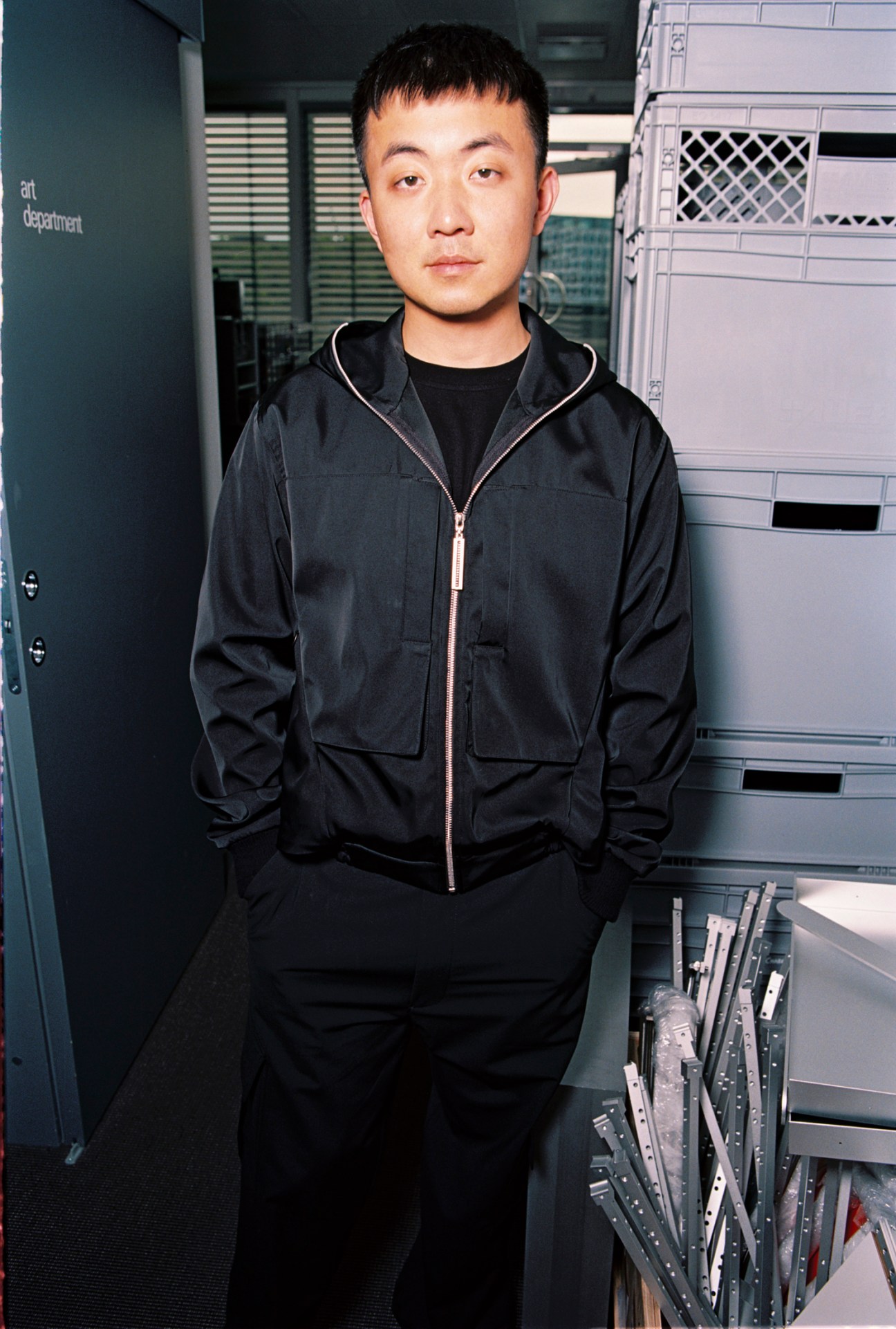 Carl Pei, co-founder of Nothing, standing in a modern industrial office space wearing a black zip-up jacket