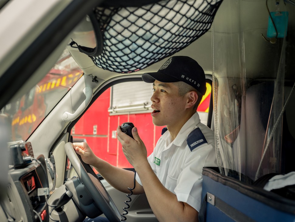Paramedic in uniform speaking on radio inside emergency vehicle on Cheung Chau island
