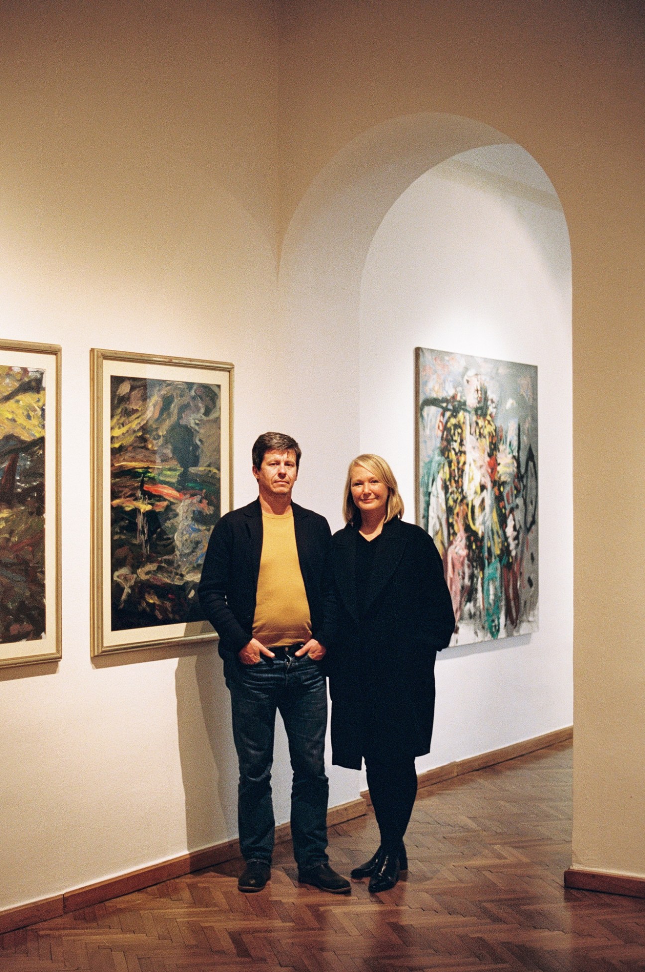 Matevz Celik and Simona Vidmar standing together in an art gallery with paintings on white walls