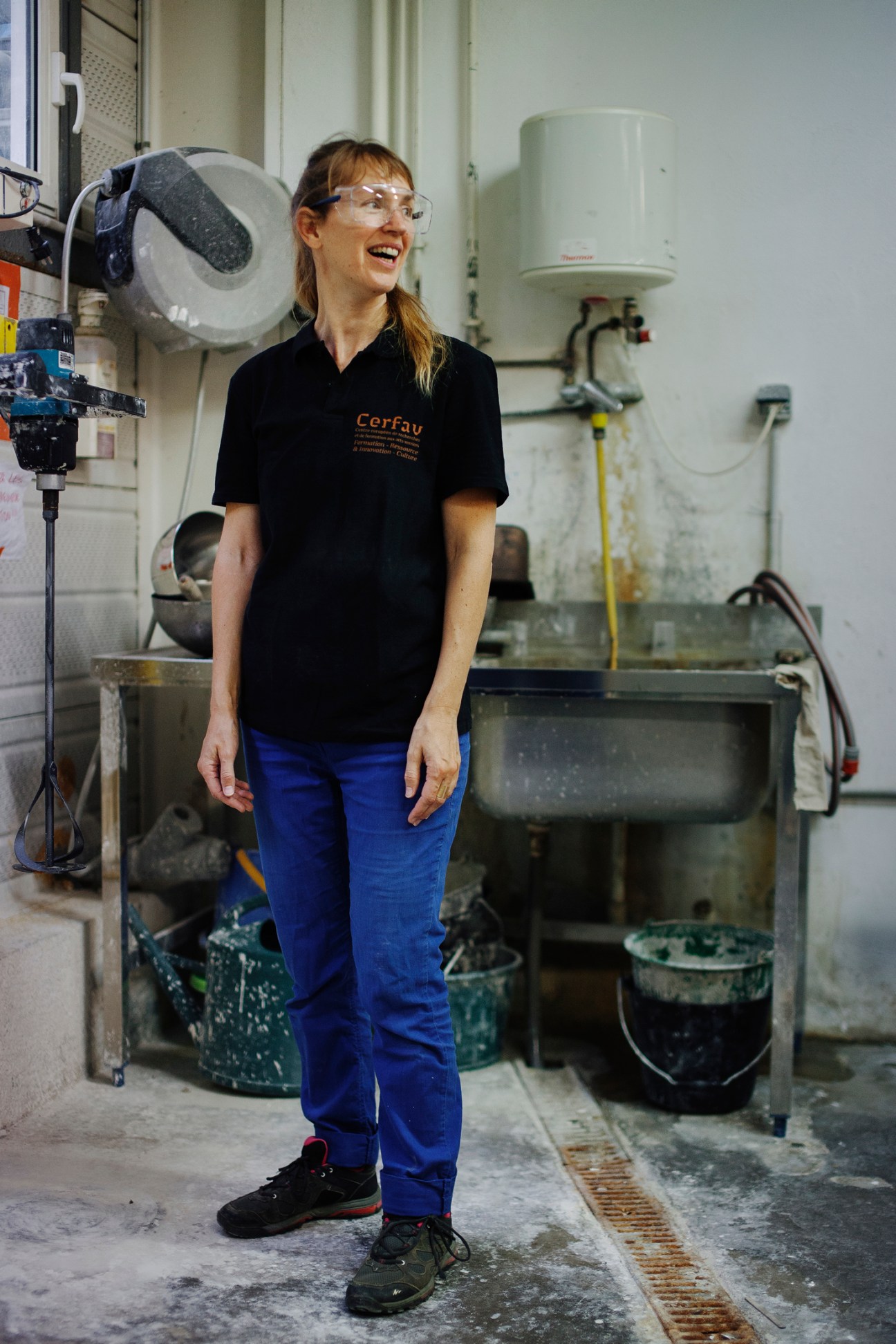 Marie-Alice Skaper wearing safety glasses and black polo shirt in glass-making workshop