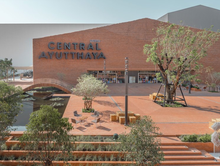 Central Ayutthaya shopping center exterior with brick facade, landscaped plaza, water features and pedestrian bridge