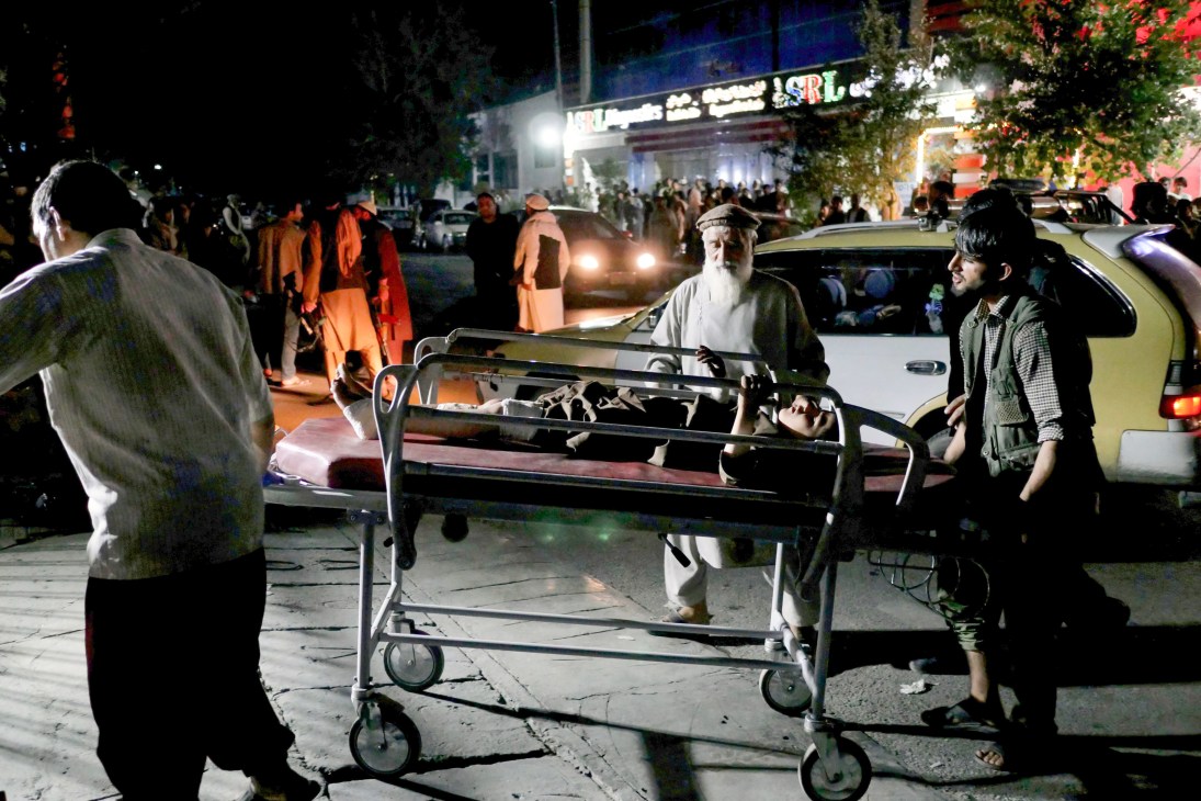 Medical personnel transport a young boy on a stretcher into an emergency hospital in Kabul following an airport bombing blast.