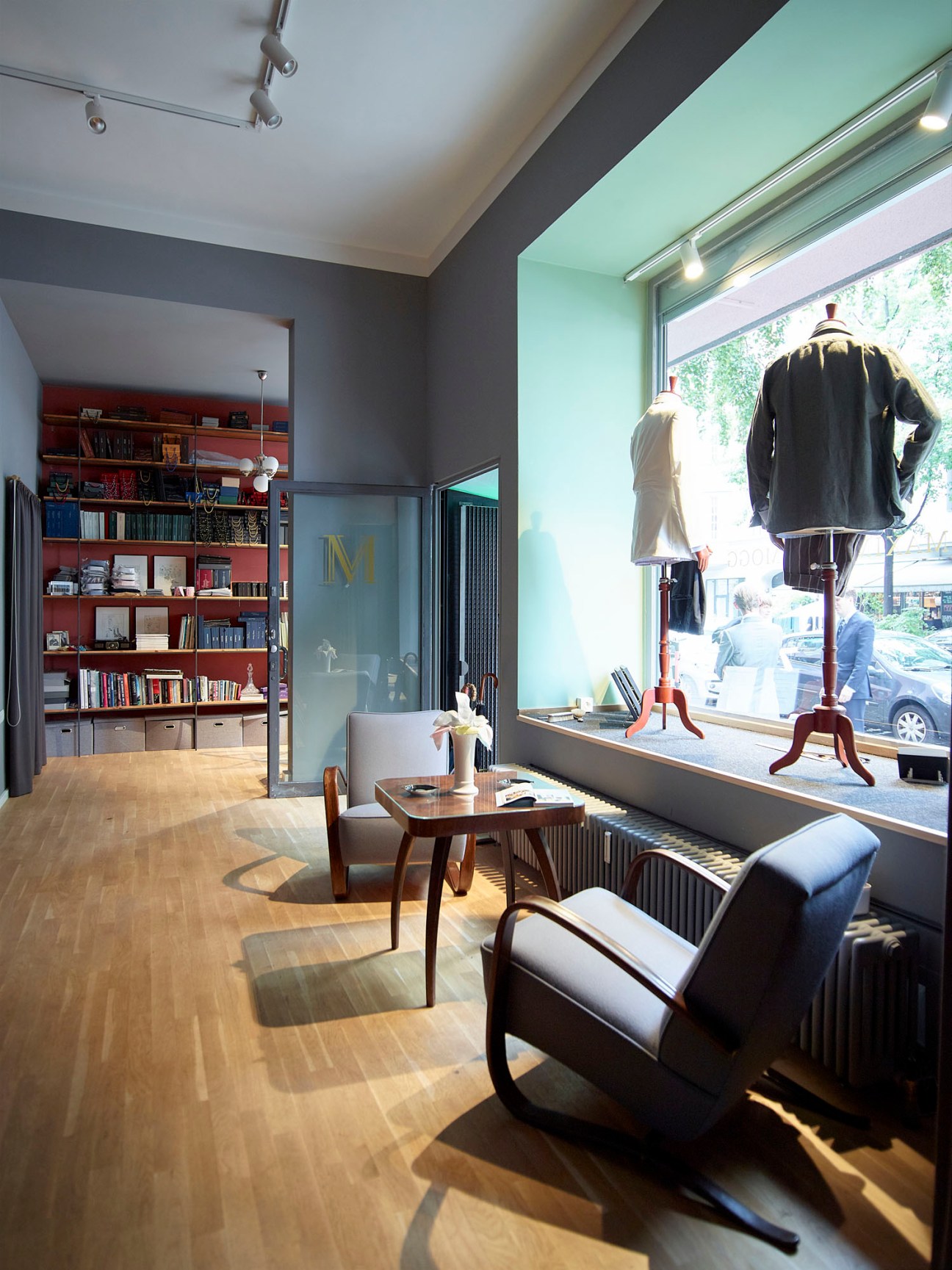 Interior of Maximilian Mogg's Berlin flagship store showing modern retail space with suits on display and bookshelves