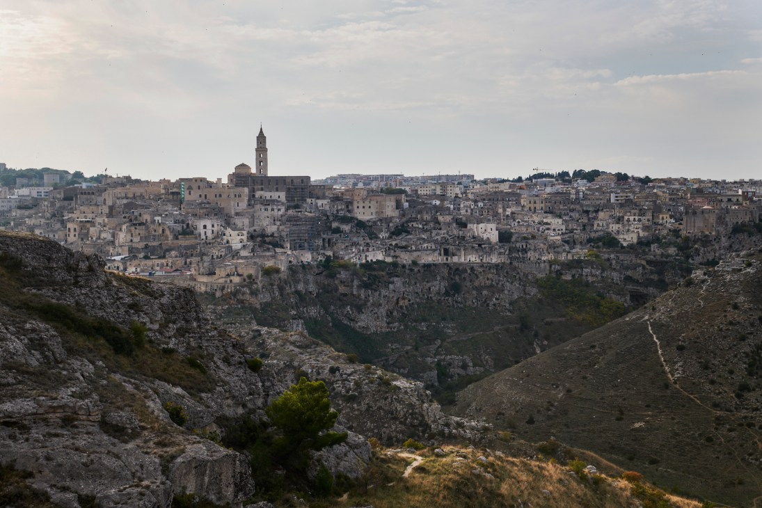 Historic hilltop town of Matera with ancient stone buildings cascading down rocky cliffs in Basilicata.