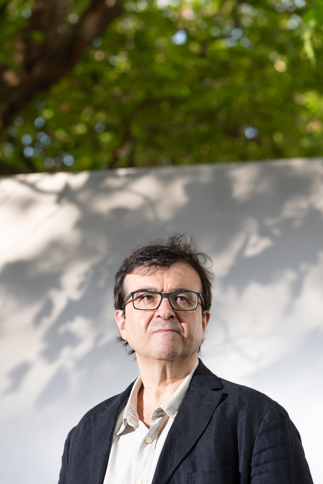 Javier Cercas wearing glasses and a dark jacket in an outdoor portrait
