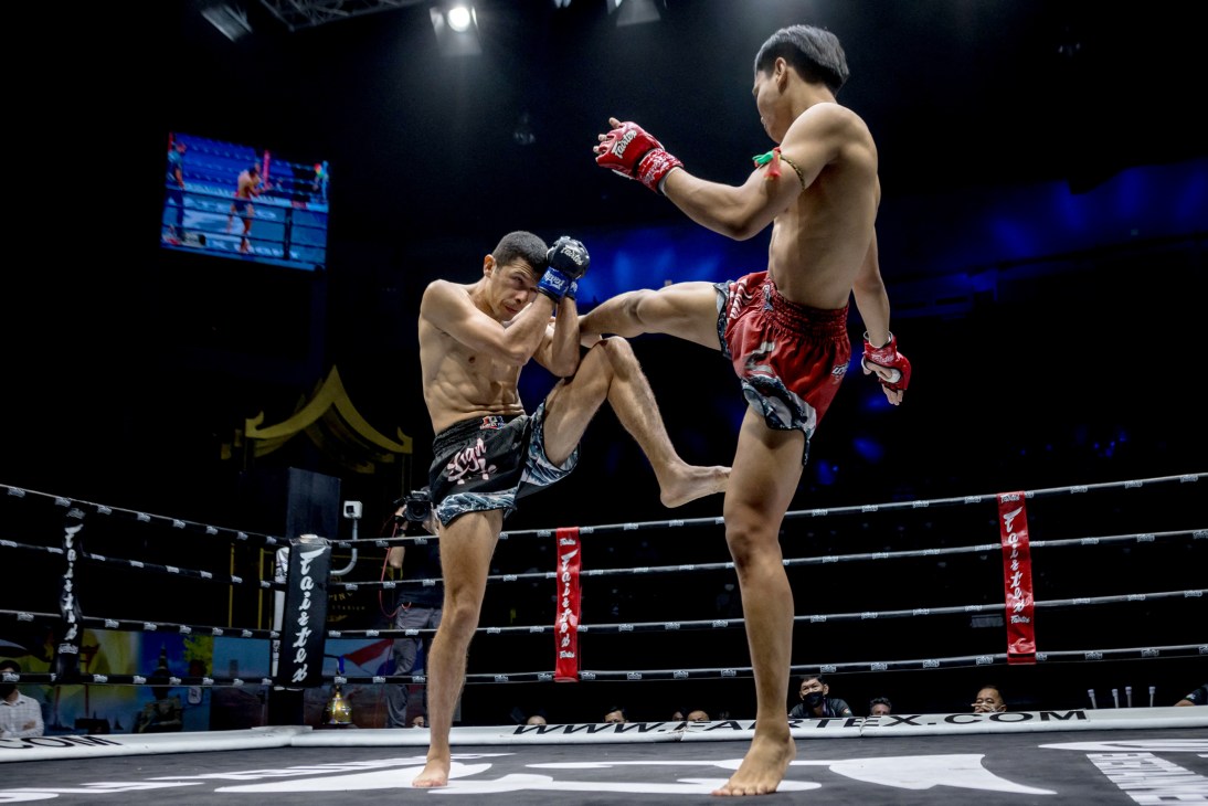 Two Muay Thai fighters in combat stance during a kickboxing match in a professional ring