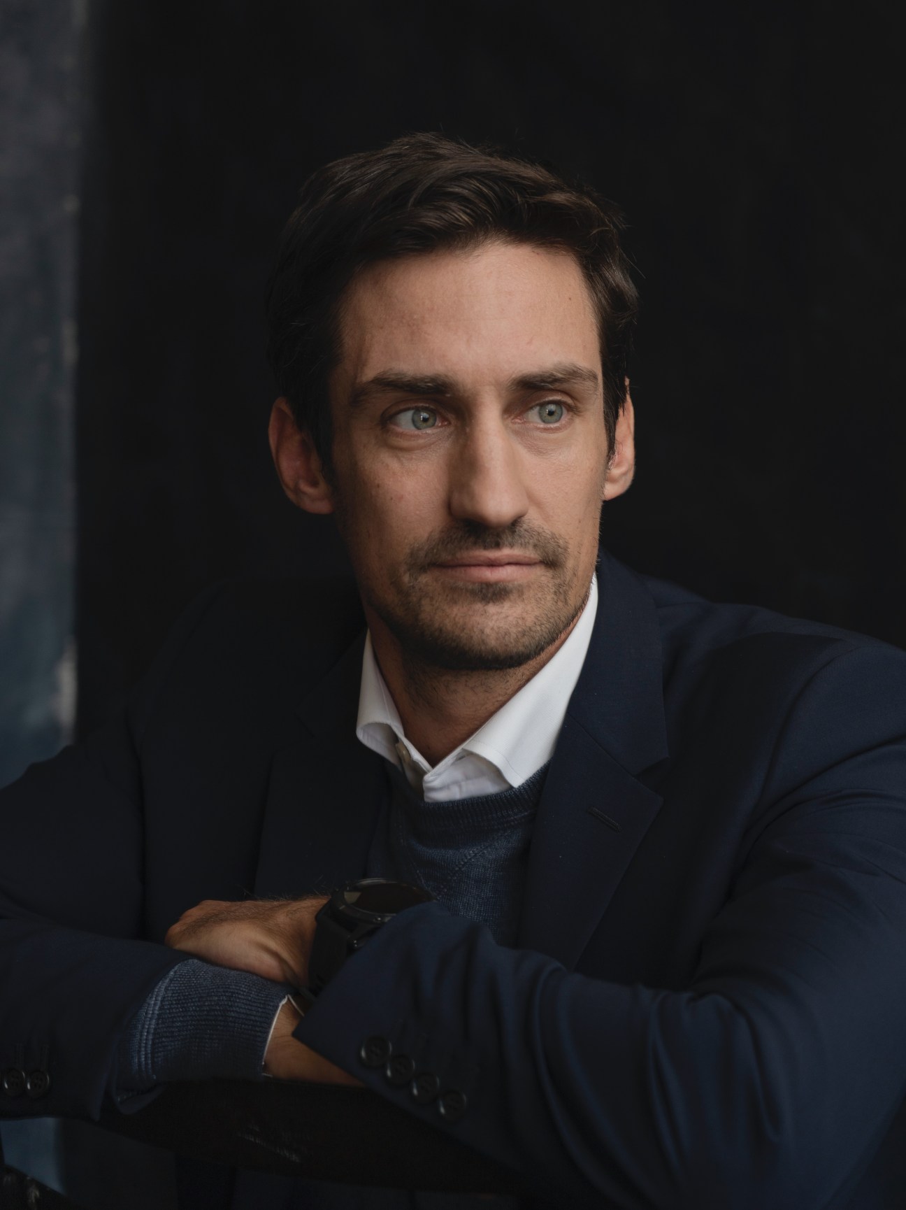 Checkout.com CEO Guillaume Pousaz in a dark blazer and white shirt against a dark background.