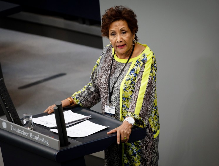 Woman speaking at the podium in a colourful top.