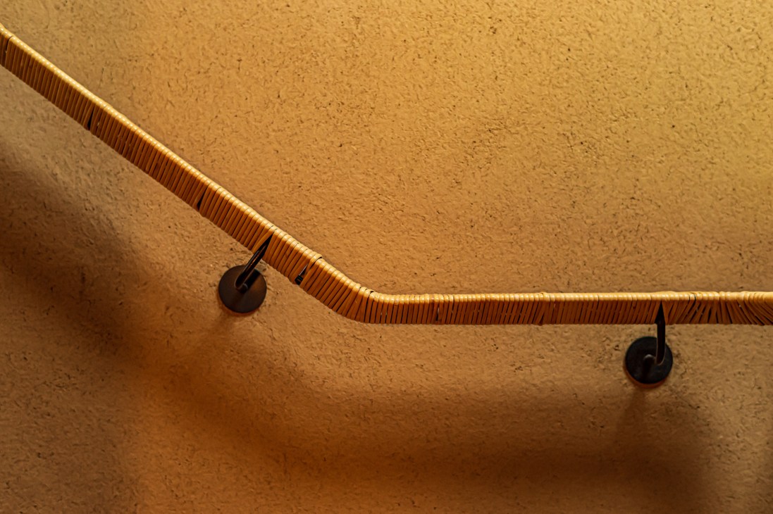 Wooden handrail with ribbed texture mounted on wall with metal brackets