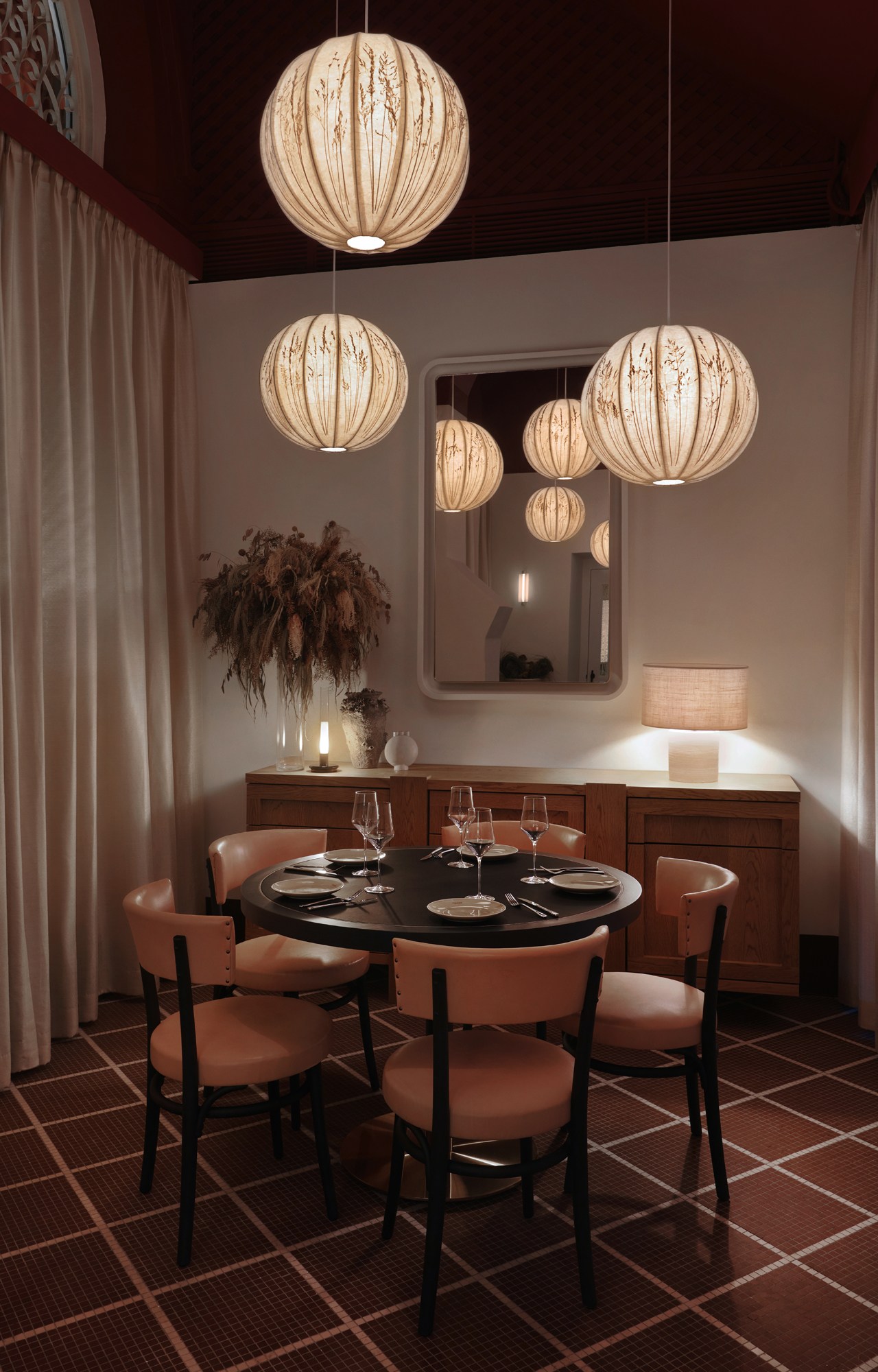 Elegant private dining room with spherical pendant lights, round black table, and warm earth-toned decor