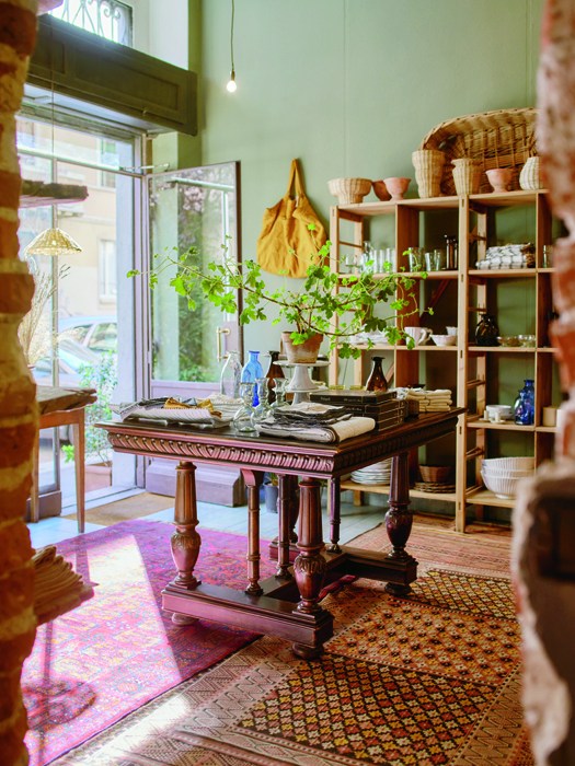 Interior of Vicolo Via Mameli homeware shop in Milan showing wooden desk, shelving with ceramics and rustic decor