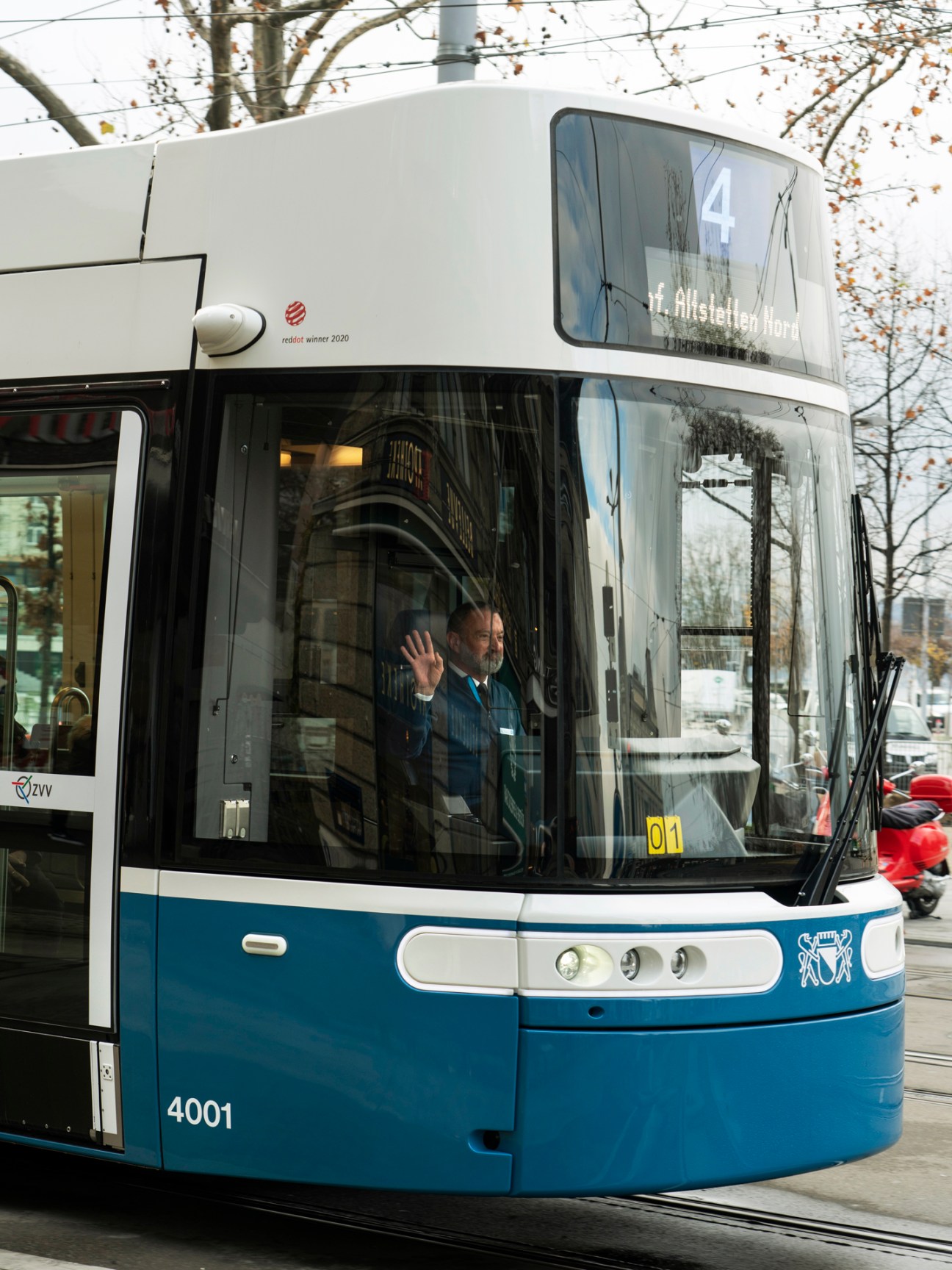 Blue and white Zürich tram number 4001 on city street with driver visible through windscreen
