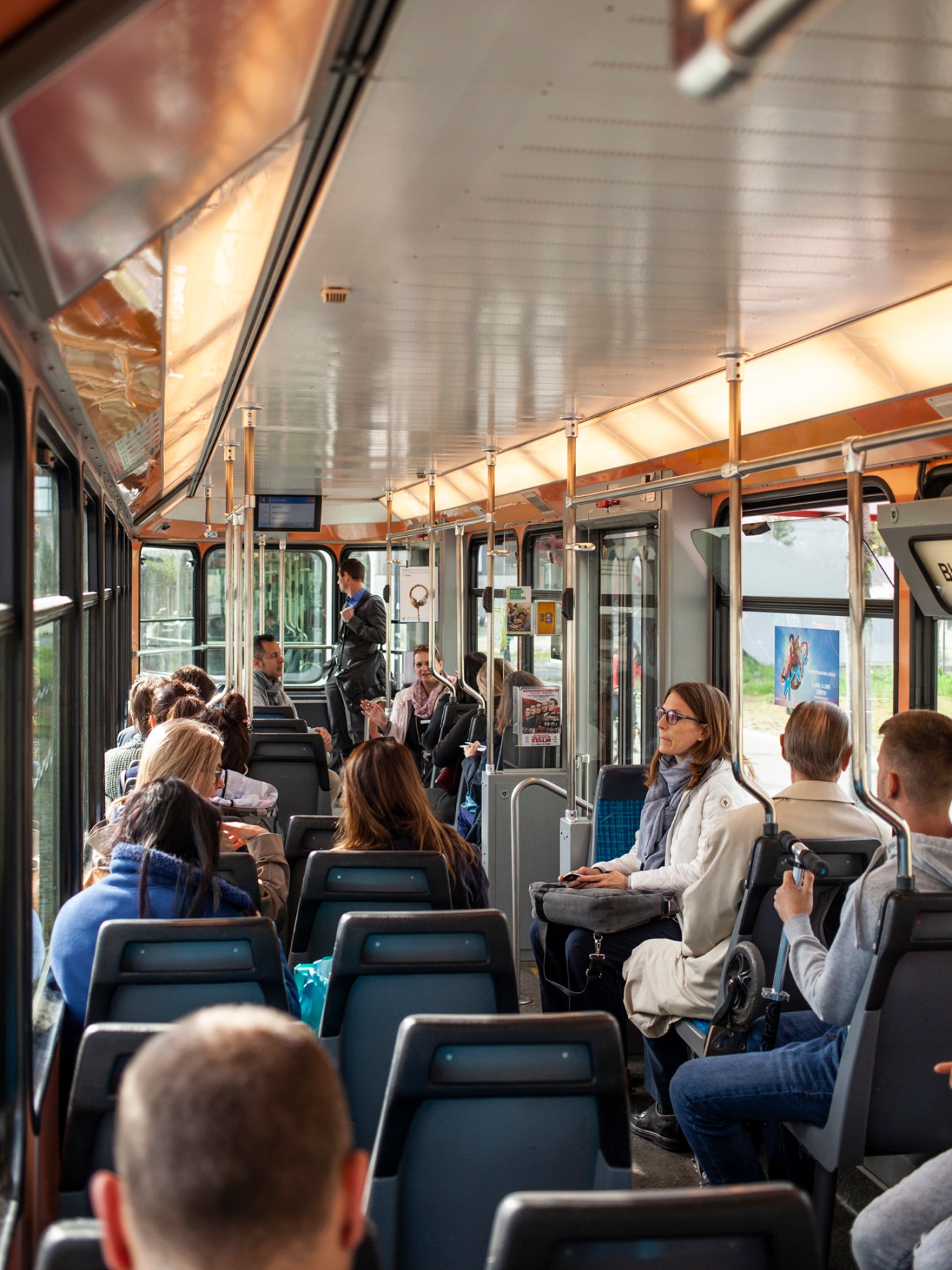 Interior of Zürich tram with passengers seated and standing, showing modern design and lighting