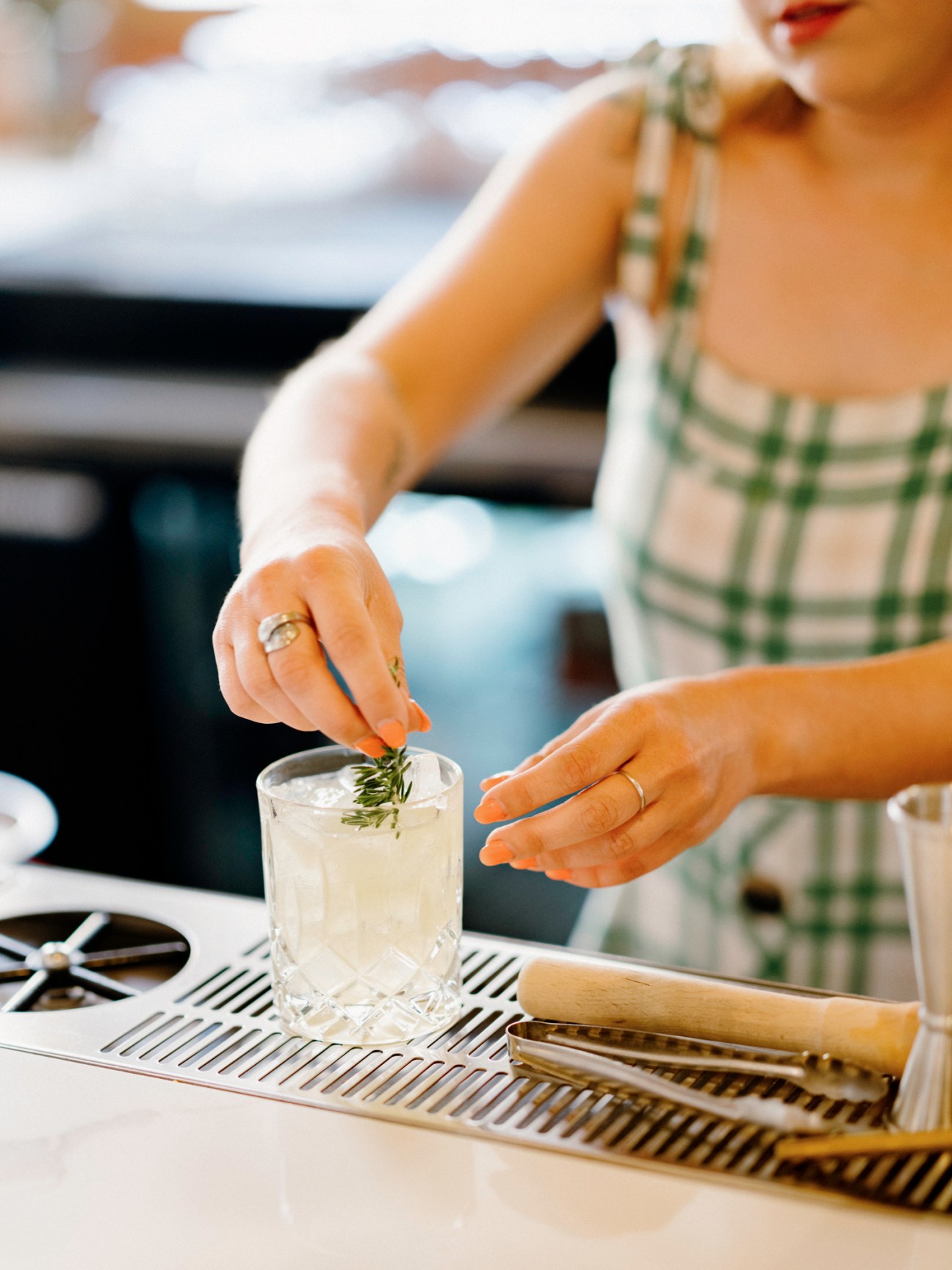 Bartender garnishing cocktail with rosemary sprig at The Citizen hotel bar