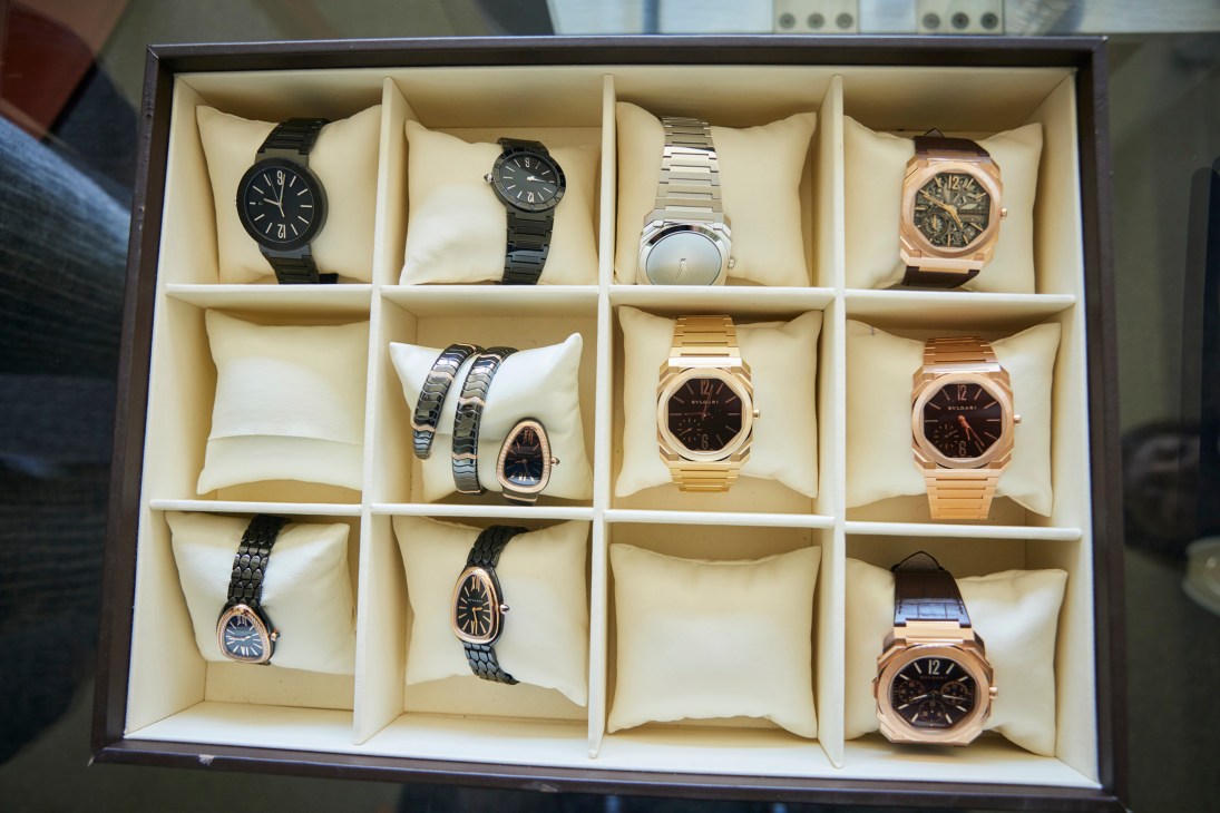 Collection of luxury watches displayed in an organized watch box with compartments