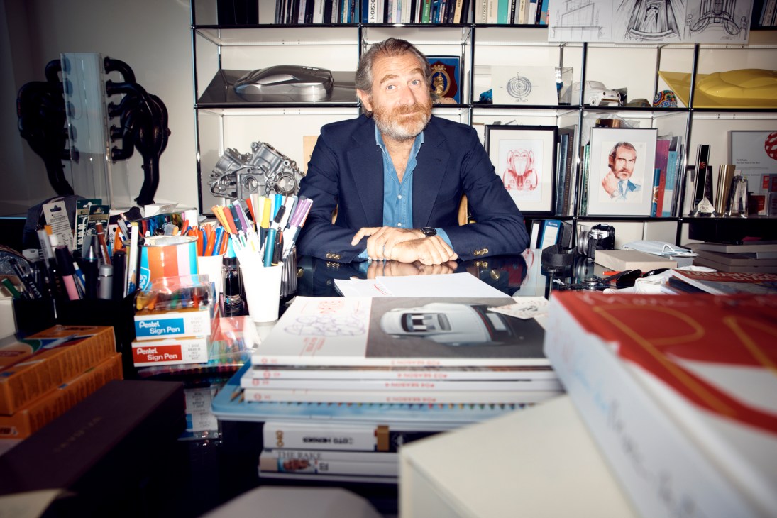 Fabrizio Buonamassa Stigliani sitting at his desk in his office with shelves of books and design materials behind him