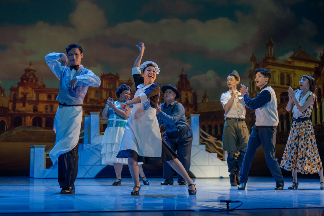 Performers rehearsing on stage at TPAC in period costumes with theatrical lighting and painted backdrop