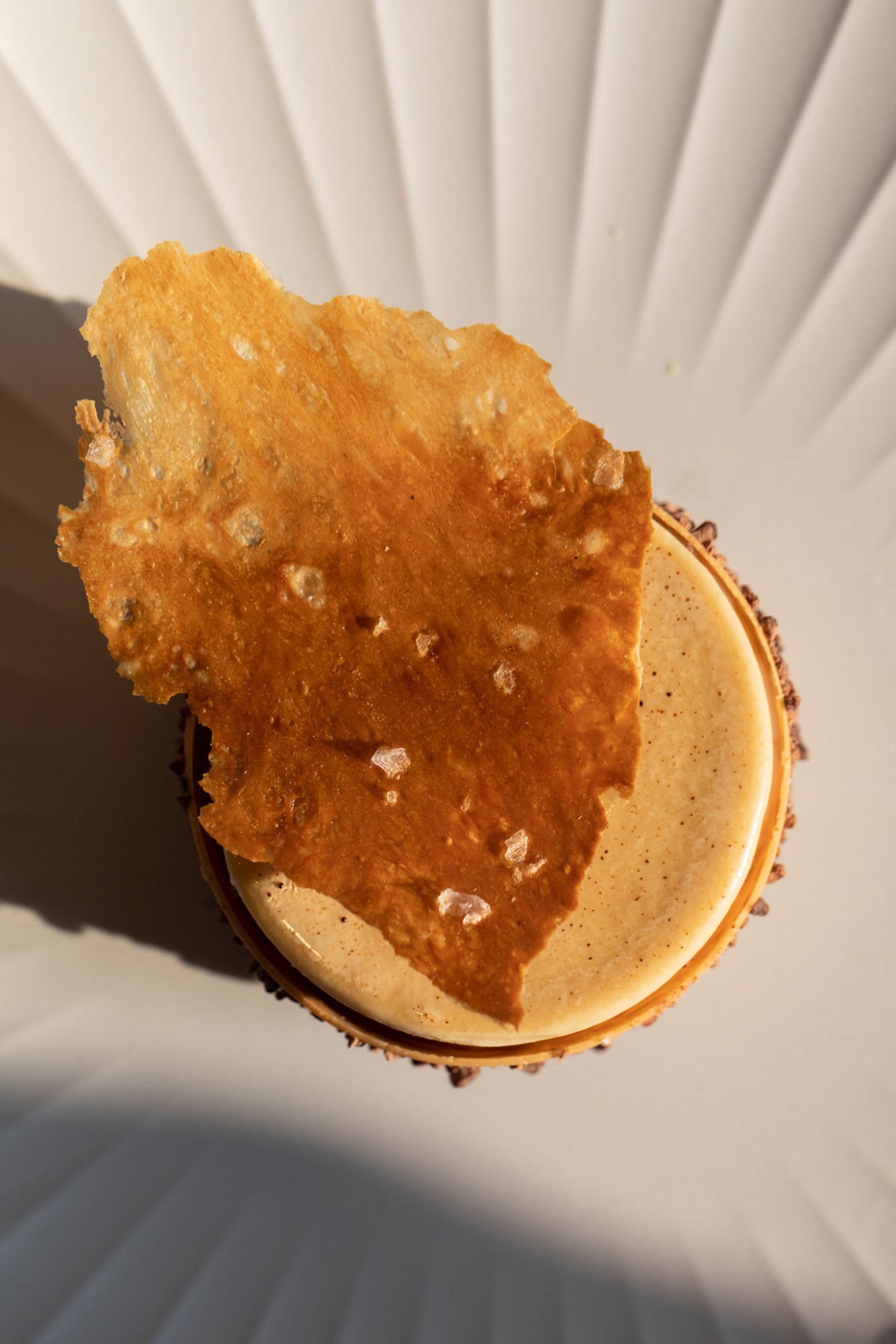 Golden honeycomb candy garnish on top of a smooth beige dessert