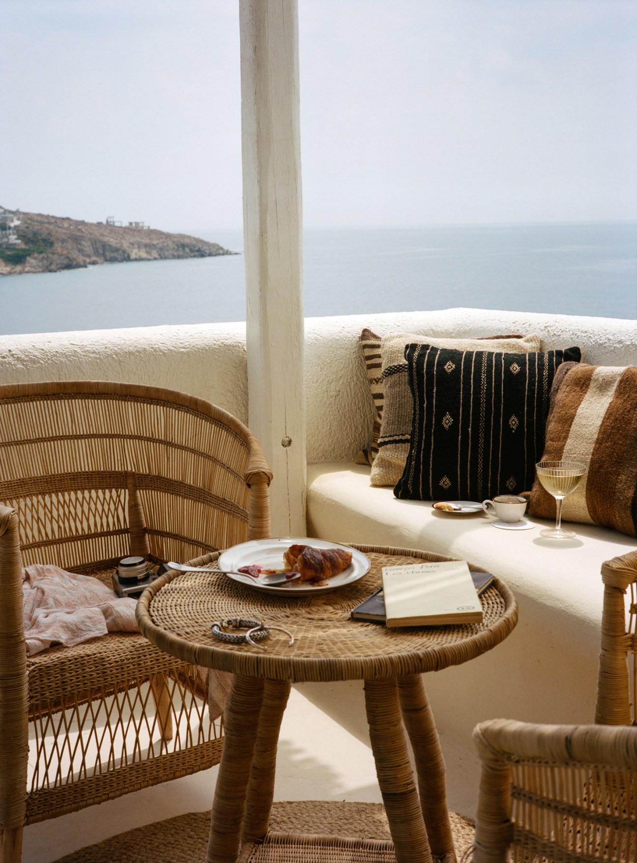 Soho Roc House bedroom terrace with wicker chair, cushioned seating, and Mediterranean sea view.