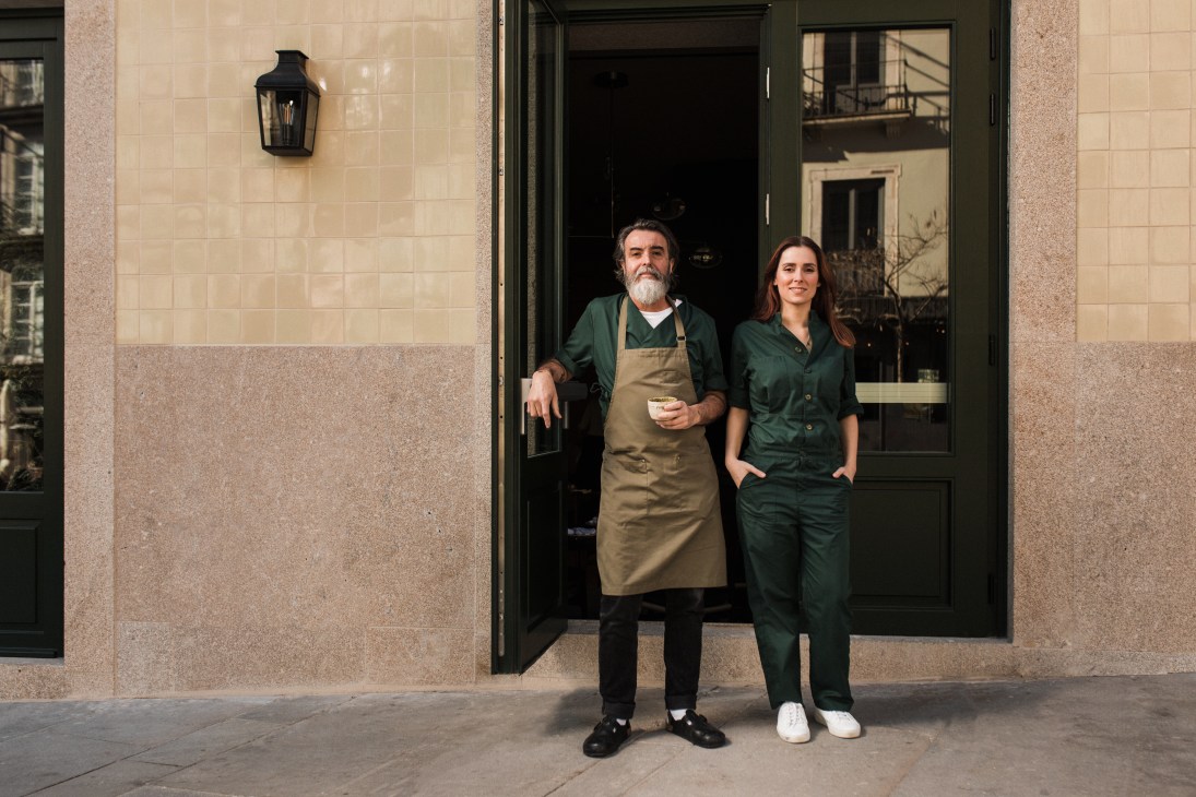 Chef Nuno Mendes and Tatiana Cardoso standing together in restaurant doorway wearing green uniforms